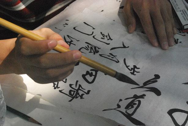 someone writing chinese calligraphy